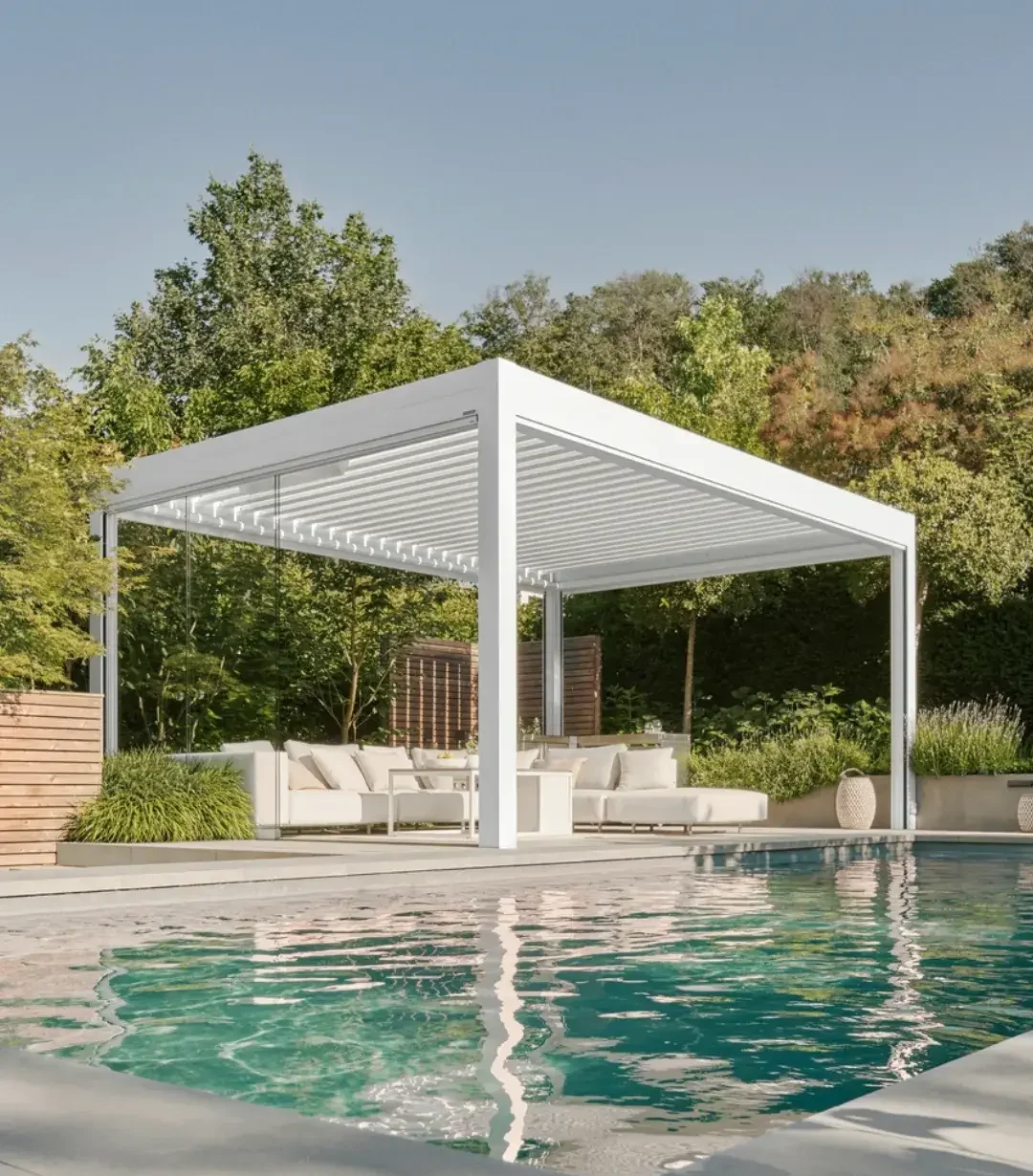 Freistehendes Lamellendach in Weiß am Pool, darunter eine helle Lounge-Sitzgruppe